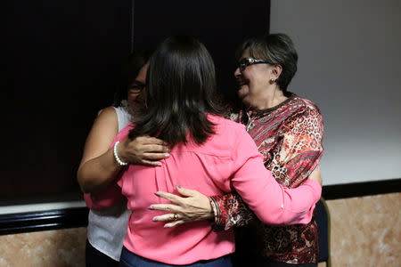 Relatives of former Salvadoran army officers embrace each other after receiving news that the Supreme Court suspended arrest warrants against soldiers for their alleged involvement in the 1989 massacre of Jesuit priests during the civil war, in San Salvador, El Salvador, August 22, 2017. REUTERS/Jose Cabezas