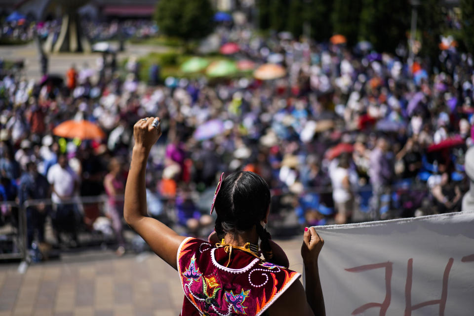 Sarain Fox of the Batchewana First Nation demonstrates outside the mass presided over by Pope Francis at the National Shrine of Saint Anne de Beaupre, Thursday, July 28, 2022, in Saint Anne de Beaupre, Quebec. Pope Francis is on a "penitential" six-day visit to Canada to beg forgiveness from survivors of the country's residential schools, where Catholic missionaries contributed to the "cultural genocide" of generations of Indigenous children by trying to stamp out their languages, cultures and traditions. (AP Photo/John Locher)