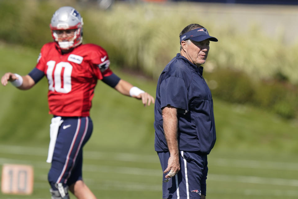 New England Patriots quarterback Mac Jones (10) warms up as head coach Bill Belichick walks on the field during an NFL football practice, Wednesday, Oct. 13, 2021, in Foxborough, Mass. (AP Photo/Steven Senne)