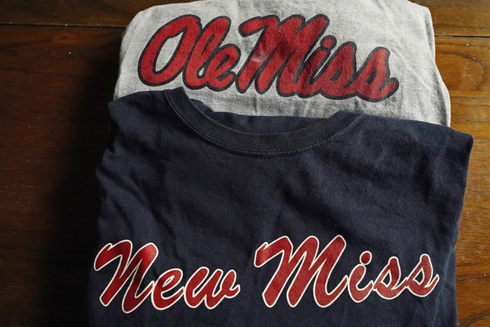 The top t-shirt is emblazoned with one of the University of Mississippi's logos, while the bottom shirt, a New Miss product, sports a logo nearly identical to the university's ubiquitous Ole Miss brand, as photographed Nov. 9, 2021 in Jackson, Miss. The university objects to the trademark application filed by the person marketing the New Miss brand. (AP Photo/Rogelio V. Solis)