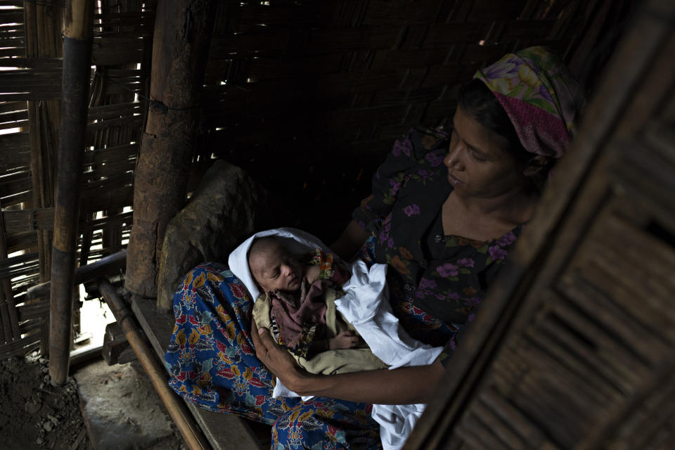 SITTWE, BURMA - MAY 06: Ku Sumakahtu holds her fifteen-day old child, beginning to suffer from malnutrition on May 6, 2014 in Sittwe, Burma. Some 150,000 Rohingya IDP (internally displaced people) are currently imprisoned in refugee camps outside of Sittwe in Rakhine State in Western Myanmar. Medecins Sans Frontieres (MSF), the primary supplier of medical care within the camps, was banned in March by the Myanmar government. Follow up attacks by Buddhist mobs on the homes of aid workers in Sittwe put an end to NGO operations in the camps. Though some NGOs are beginning to resume work, MSF remains banned, and little to no healthcare is being provided to most Rohingya IDPs. One Rohingya doctor is servicing 150,000 refugees with limited medication. Several Rakhine volunteer doctors sporadically enter the camps for two hours a day. Births are the most complicated procedures successfully carried out in the camps, requests to visit Yangon or Sittwe hospitals for life threatening situations require lengthy applications and are routinely denied. Malnutrition and diarrhea are the most widespread issues, but more serious diseases like tuberculosis are going untreated and could lead to the rise of drug resistant tuberculosis (DR-TB).  (Photo by Andre Malerba/Getty Images)