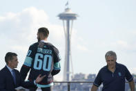 Chris Dreidger, center, a goalie from the Florida Panthers, stands with ESPN NHL hockey draft host Chris Fowler, left, and Seattle Kraken general manager Ron Francis as he is introduced Wednesday, July 21, 2021, as a new player for the Kraken during the team's expansion draft event in Seattle. (AP Photo/Ted S. Warren)