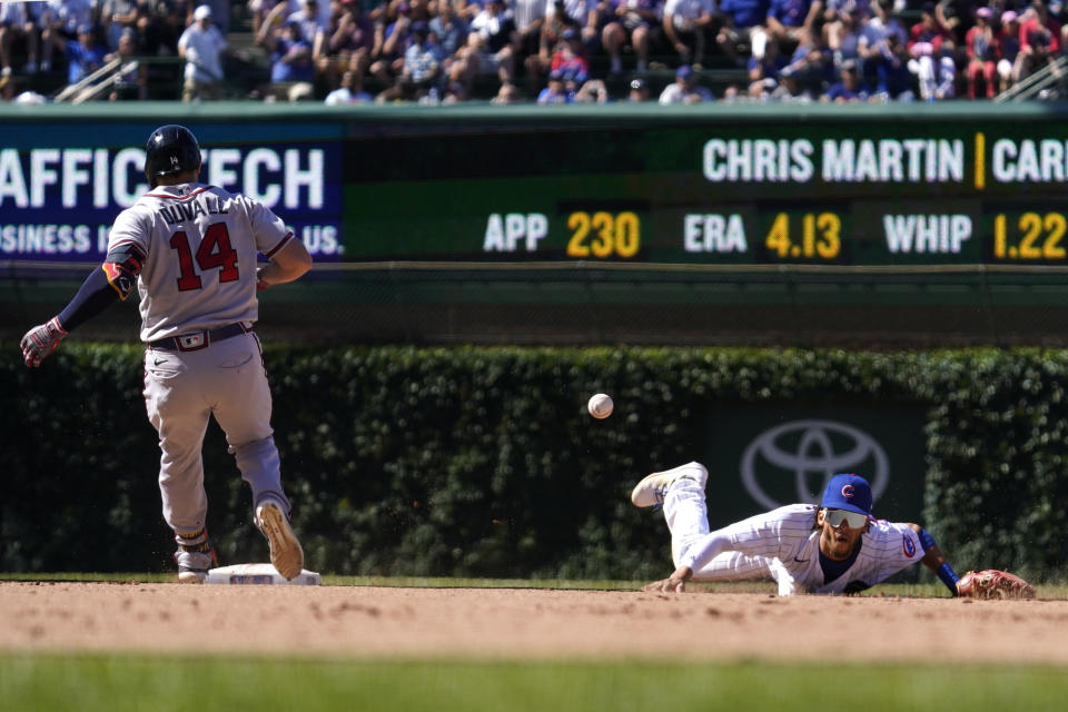 Atlanta Braves' Adam Duvall, left, arrives at second base after hitting a double as Chicago Cubs second baseman Andrelton Simmons misses a catch during the ninth inning of a baseball game in Chicago, Saturday, June 18, 2022. (AP Photo/Nam Y. Huh)