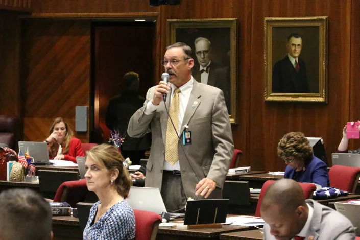 FILE - Republican Rep. Mark Finchem speaks May 2, 2018, at the Capitol in Phoenix. In the year since the Jan. 6 riot, Donald Trump-aligned Republicans have worked to clear the path for next time. In battleground states and beyond, Republicans are systematically taking hold of the once overlooked machinery of elections, weakening or replacing the checks in place to prevent partisan meddling with results. (AP Photo/Bob Christie, File)