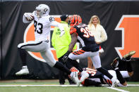 <p>Darren Waller #83 of the Oakland Raiders breaks a tackle by Jessie Bates #30 of the Cincinnati Bengals before being dragged down short of the goal line by Shawn Williams #36 during the second quarter at Paul Brown Stadium on December 16, 2018 in Cincinnati, Ohio. (Photo by Andy Lyons/Getty Images) </p>