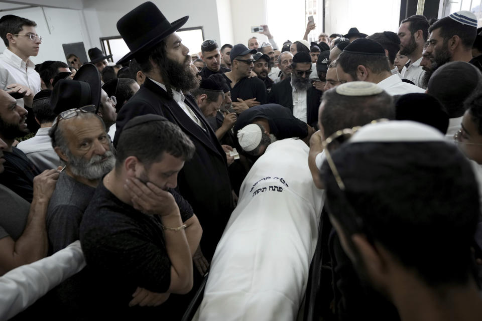 Jewish mourners gather in Petah Tikva, Israel at the funeral for Yonatan Havakuk, the day after he was killed with two others in a stabbing attack in Elad, Friday, May 6, 2022. Israeli security forces waged a massive manhunt Friday for two Palestinians suspected of carrying out the stabbing attack on Thursday near Tel Aviv that left three Israelis dead.(AP Photo/Ariel Schalit)