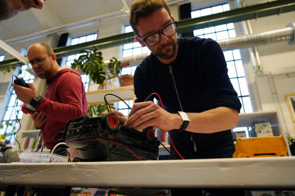 A volunteer repairs a remote control toy truck at a fortnightly repair cafe event in Malmo, southern Sweden, Sunday Nov. 14, 2021. A global network of free-of-charge repair, made by non-professionals with a bug for fixing things, comes at a time as many electronics and white goods are discarded although they could be fixed. The shops, the so-called Repair Cafes, are part of an international grassroot network calling for the “Right to Repair.” (AP Photo/James Brooks)