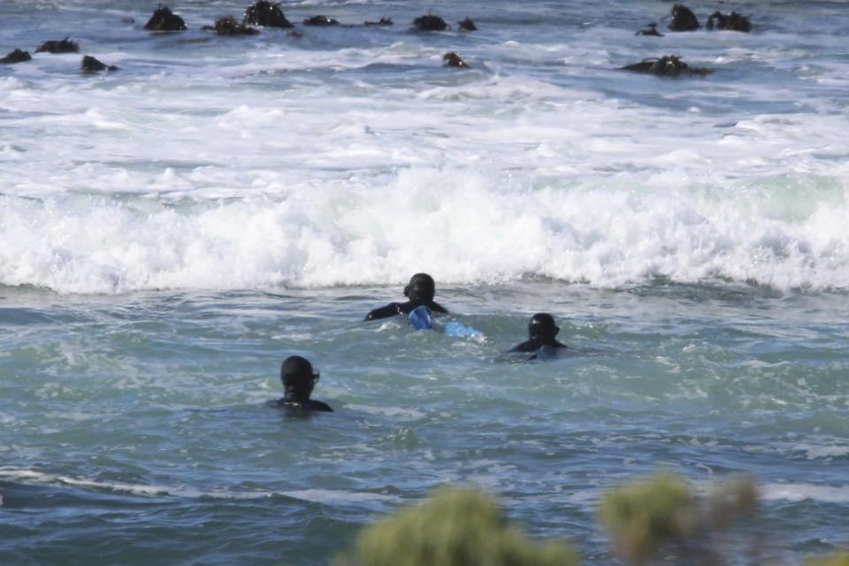 Poachers start to swim offshore at Pearly Beach, along the in Overberg District of South Africa in 2021. The poachers arrive in groups in broad daylight on pickup trucks and in their wetsuits, rubber duck boats towed behind them. (Courtesy of Community Against Abalone Poaching via AP)