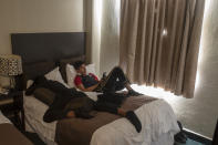 Nicaraguan migrants Edgar Sequeira, left, and Emanuel Mendoza, rest on a hotel bed in Mexicali, Mexico, Wednesday, Dec. 1, 2021. The United States and Mexico announced Thursday, a deal to re-implement under court order a Trump-era policy known as “Remain in Mexico” at Mexico’s northern border that forced asylum seekers to wait out their cases inside Mexico. (AP Photo/Felix Marquez)