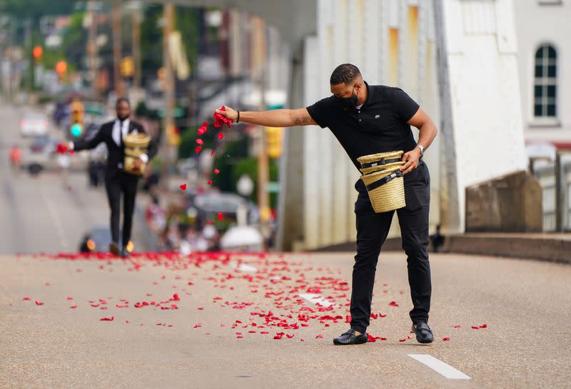 Men from the Willie Watkins Funeral Home scatter rose petals representing the blood spilled on Bloody Sunday on the Edmund Pettus Bridge, in Selma