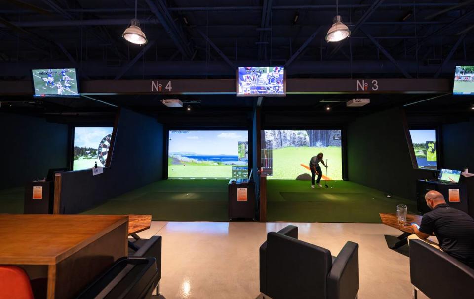 Alex Araujo and Josh Eaton practice on the virtual driving range at Swing Center Indoor Golf in Modesto, Calif., Wednesday, August 23, 2023.