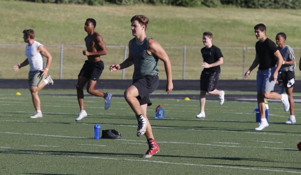 With social distancing in mind, student athletes run a drill during the re-opening of a strength and conditioning camp at Arlington Martin High School Thursday, June 18, 2020, in in Arlington, Texas. While states have been easing the economic and social lockdowns prompted by the coronavirus pandemic, some are now letting high school athletes return to campus for summer workouts before teachers have even figured out how they are going to hold classroom instruction. (AP Photo/LM Otero)