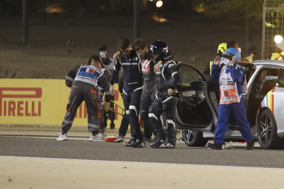 TOPSHOT - Stewards and medics attend to Haas F1's French driver Romain Grosjean after a crash at the start of the Bahrain Formula One Grand Prix at the Bahrain International Circuit in the city of Sakhir on November 29, 2020. (Photo by HAMAD I MOHAMMED / POOL / AFP) (Photo by HAMAD I MOHAMMED/POOL/AFP via Getty Images)