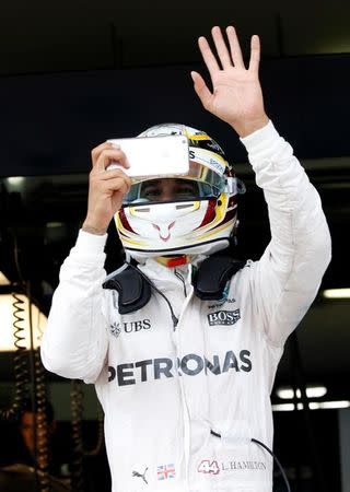 Formula One - F1 - Malaysia Grand Prix - Sepang, Malaysia- 30/9/16 Mercedes' Lewis Hamilton of Britain waves to his fans as he takes a photo after second practice. REUTERS/Edgar Su