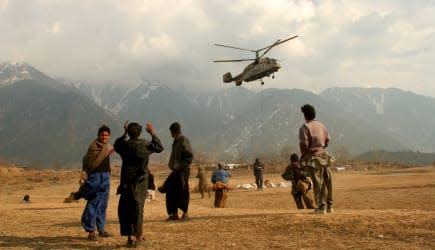 APTOPIX PAKISTAN SOUTH ASIA EARTHQUAKE (People watch a helicopter from the World Food Program arrive at the village of Paca Biak