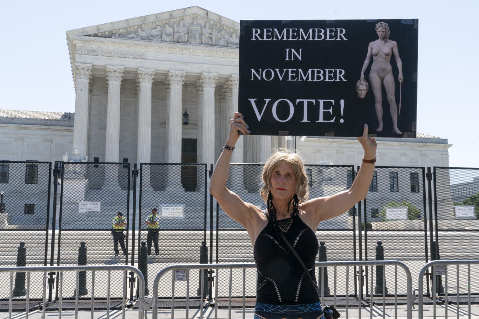 FILE - Nicky Sundt, of Washington, holds a sign with an image depicting Medusa that says, "Remember in November, Vote!," outside of the Supreme Court, June 29, 2022, in Washington. Democrats are pumping an unprecedented amount of money into advertising related to abortion rights, underscoring how central the message is to the party in the final weeks before the November midterm elections. (AP Photo/Jacquelyn Martin, File)