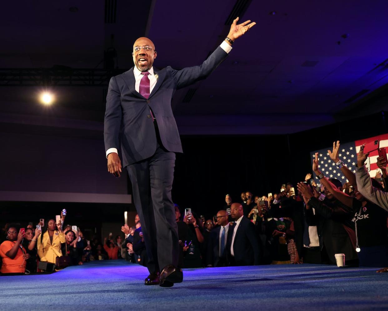 Sen. Raphael Warnock of Georgia waves to a crowd on election night. <a href="https://www.gettyimages.com/detail/news-photo/georgia-democratic-senate-candidate-u-s-sen-raphael-warnock-news-photo/1447288285?phrase=warnock+raphael&adppopup=true" rel="nofollow noopener" target="_blank" data-ylk="slk:Win McNamee/Getty Images;elm:context_link;itc:0;sec:content-canvas" class="link ">Win McNamee/Getty Images</a>