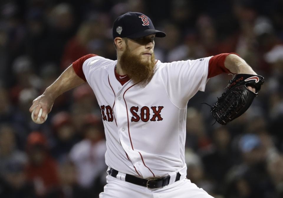 FILE - In this Oct. 23, 2018, file phoo, Boston Red Sox's Craig Kimbrel throws during the ninth inning of Game 1 of the World Series baseball game against the Los Angeles Dodgers in Boston. Kimbrel, Bryce Harper, Manny Machado, and Dallas Keuchel will not be around when the bat and ball bags are opened at spring training throughout Florida and Arizona this week. They are among the dozens of free agents still looking for jobs. (AP Photo/Matt Slocum, File)