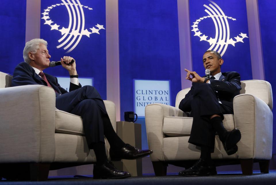 Former U.S. President Bill Clinton (L) listens to U.S. President Barack Obama speak about healthcare at the Clinton Global Initiative in New York September 24, 2013. REUTERS/Kevin Lamarque (UNITED STATES - Tags: POLITICS HEALTH)