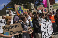 Climate activists perform with posters during a climate protest alongside the World Economic Forum in Davos, Switzerland, Thursday, May 26, 2022. The annual meeting of the World Economic Forum is taking place in Davos from May 22 until May 26, 2022. (AP Photo/Evgeniy Maloletka)