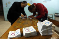 Election workers count ballots at the end of three-day vote of the referendum on constitutional amendments at polling station in Cairo, Egypt, Monday, April 22, 2019. Egyptians are voting on constitutional amendments that would allow el-Sissi to stay in power until 2030. Ballots at right are signed yes, at center signed no, at left are spoiled ballots.(AP Photo/Amr Nabil)