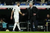 Real Madrid's Karim Benzema shakes hands with Real Madrid's head coach Carlo Ancelotti after being substituted during a Spanish La Liga soccer match between Real Madrid and Villarreal at the Santiago Bernabeu stadium in Madrid, Saturday, April 8, 2023. (AP Photo/Jose Breton)