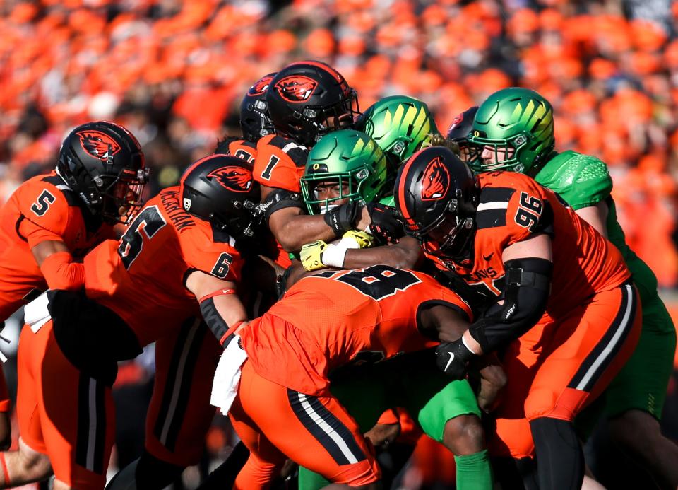 Oregon State defense piles on Oregon running back Noah Whittington (22) during the annual rivalry game on Saturday, Nov. 26, 2022 at Reser Stadium in Corvallis, Ore. 