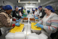 Volunteers from the charity 'The Felix Project' prepare meals in the kitchen of their hub in London, Wednesday, May 4, 2022. Across Britain, food banks and community food hubs that helped struggling families, older people and the homeless during the pandemic are now seeing soaring demand. The cost of food and fuel in the U.K. has risen sharply since late last year, with inflation reaching the highest level in 40 years. (AP Photo/Frank Augstein)