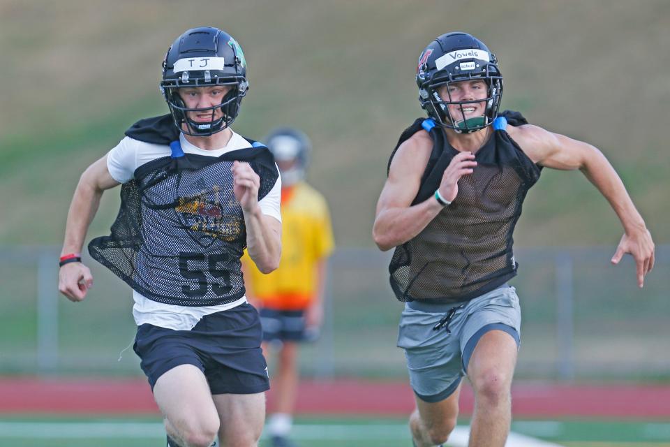North Smithfield/Mount St. Charles' TJ Smith, left, and Cole Vowels sprint during conditioning drills Monday, the first day of football practice for the Northmen and the rest of the state.