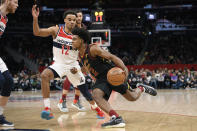Cleveland Cavaliers guard Collin Sexton (2) dribbles the ball next to Washington Wizards guard Jerome Robinson (12) during the first half of an NBA basketball game Friday, Feb. 21, 2020, in Washington. (AP Photo/Nick Wass)