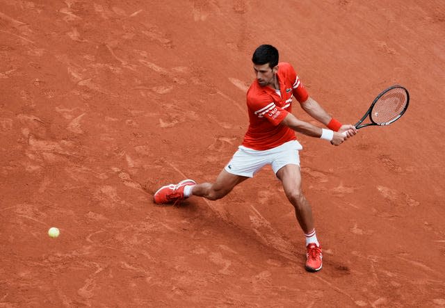 Novak Djokovic slides into a backhand