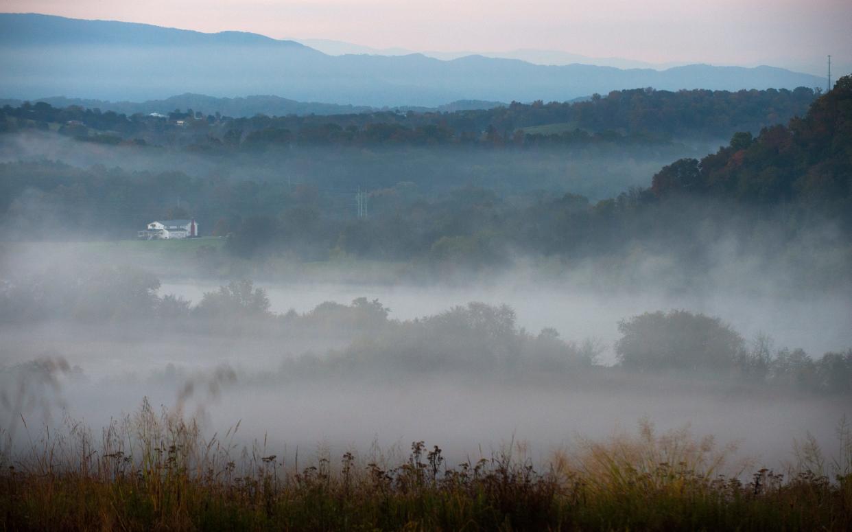 Lifting morning fog unveils the French Broad River, center, and the rising peaks of the Smokies, background, from an overlook in Seven Islands State Birding Park in Kodak on Monday, Oct. 27, 2014.