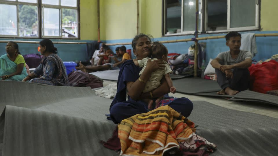 A woman holds a child inside a relief shelter after flash floods, caused by a lake burst in Singtam, Sikkim, India, October 8, 2023.  - Francis Mascarenhas/Reuters