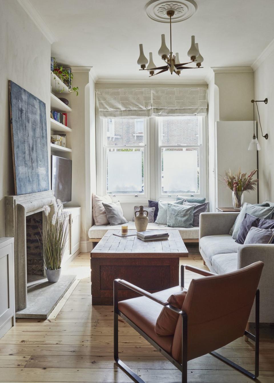 modern living room painted in off white with wooden floors, grey sofas and wooden coffee table