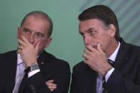 Brazil's President Jair Bolsonaro, right, talks with his Chief of Staff Onyx Lorenzoni during a cabinet presentation ceremony at the presidential palace in Brasilia, Brazil, Wednesday, Jan. 2, 2019. (AP Photo/Eraldo Peres)