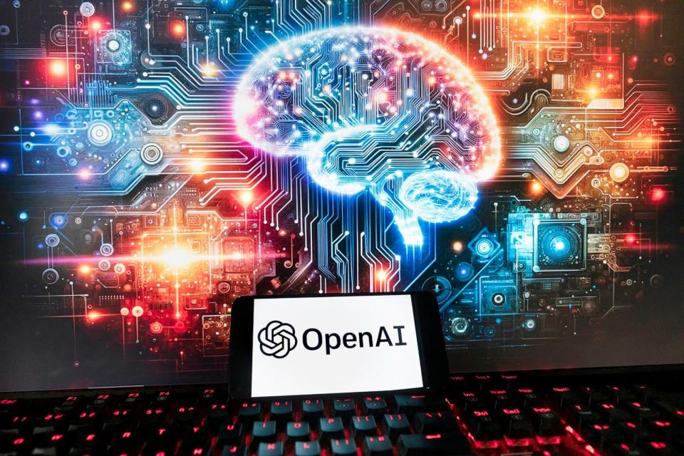 PHOTO: The OpenAI logo is displayed on a cell phone with an image on a computer monitor generated by ChatGPT's Dall-E text-to-image model, Dec. 8, 2023, in Boston. (Michael Dwyer/AP)