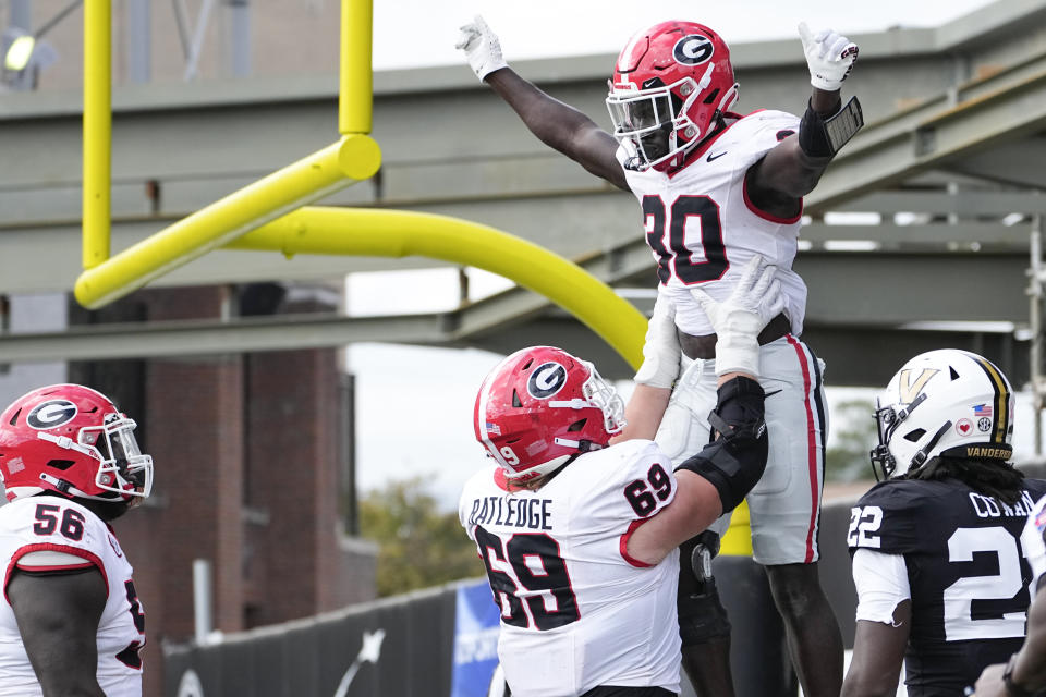 Georgia running back Daijun Edwards, second from right, celebrates a touchdown with offensive lineman Tate Ratledge (69) in the second half of an NCAA college football game against Vanderbilt, Saturday, Oct. 14, 2023, in Nashville, Tenn. Georgia won 37-20. (AP Photo/George Walker IV)