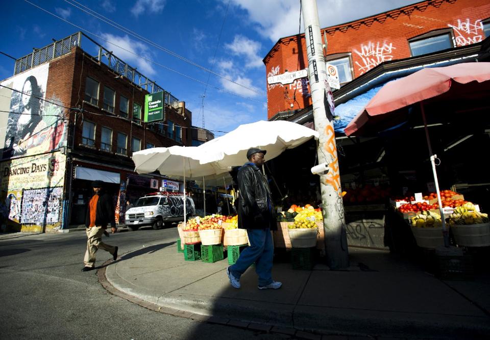 This Nov. 14, 2012 photo shows people walking around at Kensington Market in Toronto. Pedestrian Sundays are always fun when the streets are filled with bands, buskers and Brazilian drummers. (AP Photo/The Canadian Press, Nathan Denette)