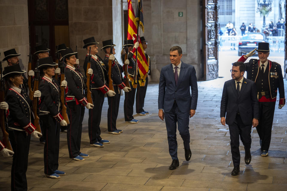 Spanish Prime Minister Pedro Sanchez walks with Catalonia's President Pere Aragones, right, during a meeting in Barcelona, Spain, Thursday, Dec. 21, 2023. Sanchez and Aragones meet in the first encounter since an amnesty for Catalan separatists was announced earlier this year. (AP Photo/Emilio Morenatti)