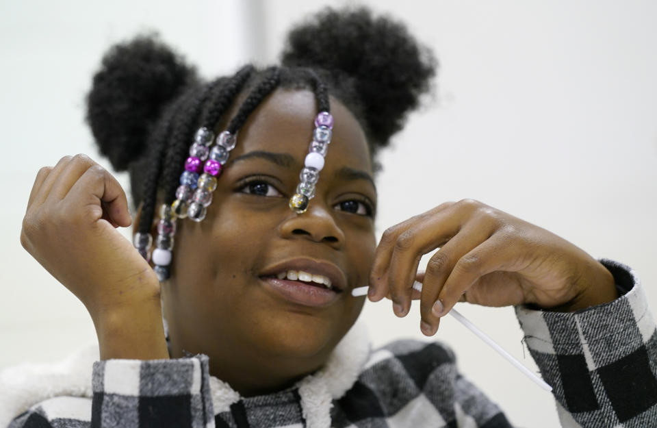 Hopewell 4th grader Cha'Niyah Wooden gestures during an interview at an after school program at a community center Thursday, Nov. 17, 2022, in Hopewell, Va. The schools in Hopewell, Va., went to a year-round schedule in 2021. (AP Photo/Steve Helber)