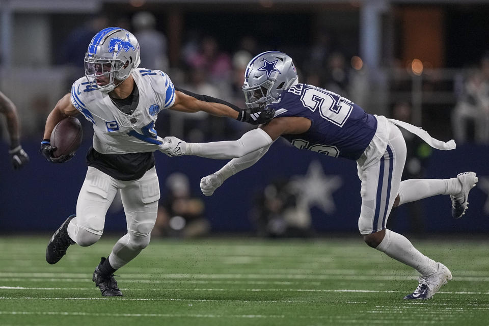 Detroit Lions wide receiver Amon-Ra St. Brown (14) carries the ball as Dallas Cowboys cornerback DaRon Bland (26) attempts a tackle during the first half of an NFL football game, Saturday, Dec. 30, 2023, in Arlington, Texas. (AP Photo/Sam Hodde)