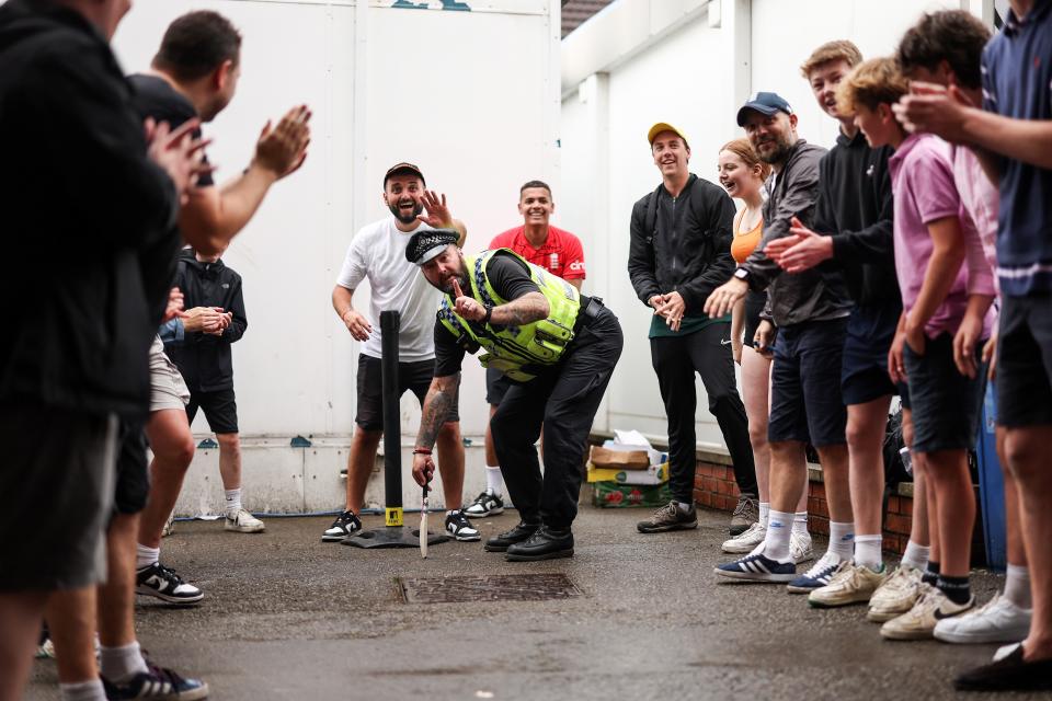 A Policeman joins in a game of cricket under the Western Terrace (Getty Images)