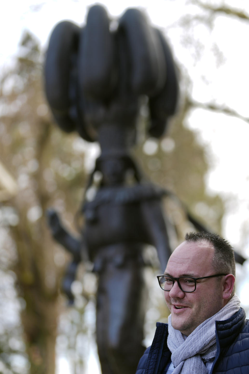 New Gilles of Binche, Charly Rombeaux, speaks next to a statue of a Gilles of Binche in Binche, Belgium, Wednesday, Feb. 1, 2023. After a COVID-imposed hiatus, artisans are putting finishing touches on elaborate costumes and floats for the renowned Carnival in the Belgian town of Binche, a tradition that brings together young and old and is a welcome moment of celebration after a rough few years. (AP Photo/Virginia Mayo)