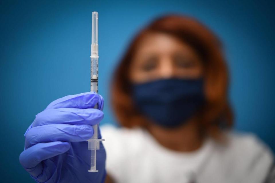 Talisha Johnson of KC CARE Health Center displayed a dose of the Pfizer COVID-19 vaccine at a walk-in vaccination clinic at the Northeast branch of the Kansas City Public Library.