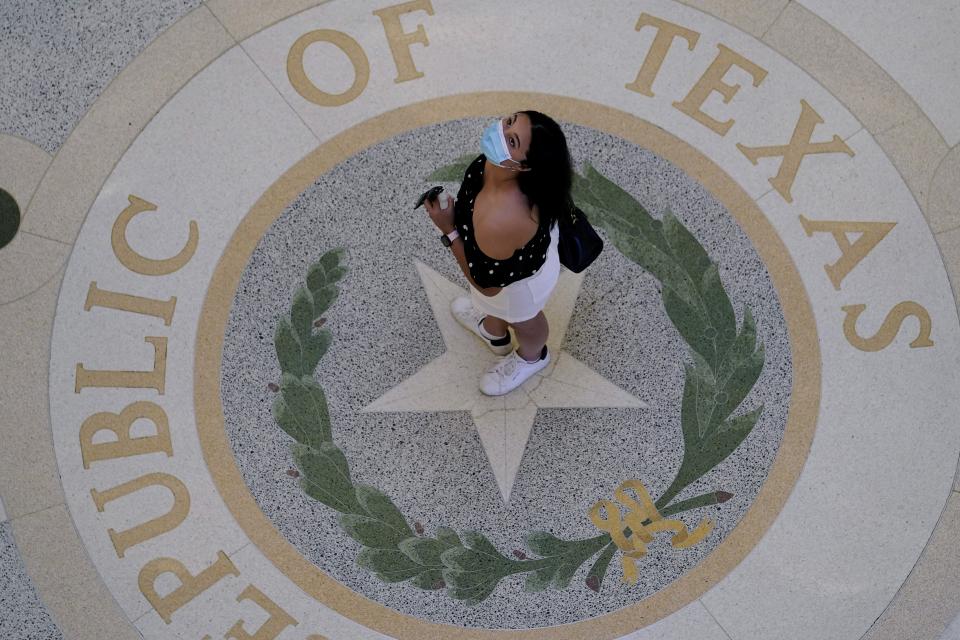 A visitor wears a protective mask during a visit Thursday to the Capitol. In a Texas Senate committee meeting earlier in the week, hospital executives said that finding nurses to treat the recent surge in COVID-19 patients has been especially difficult, with many leaving the profession because of the pandemic’s toll.