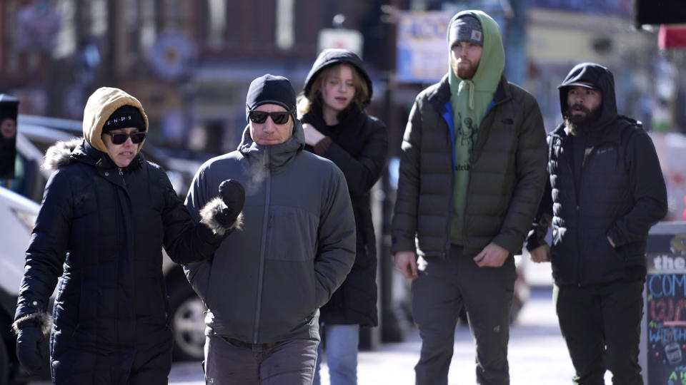 Pedestrians are bundled up in cold weather clothing while walking during a frigid weather snap, Friday, Feb. 3, 2023, in Portsmouth, N.H. Windchills in New England are expected to be sub-zero on Friday and Saturday across the region. (AP Photo/Charles Krupa)