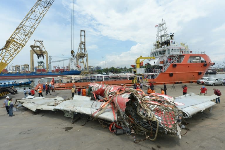 Indonesian workers remove the fuselage of AirAsia QZ8501 from a vessel at the Tanjung Priok port in Jakarta on March 2, 2015