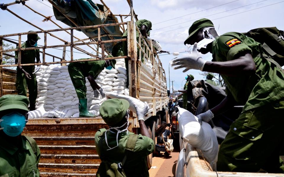 Members of a local defence unit distributing food – but they have also been accused of being too heavy handed in enforcing lockdown - Reuters