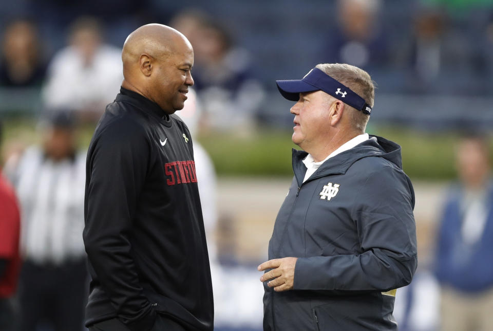 Stanford coach David Shaw, left, meets with Notre Dame coach Brian Kelly before an NCAA college football game Saturday, Sept. 29, 2018, in South Bend, Ind. (AP Photo/Carlos Osorio)