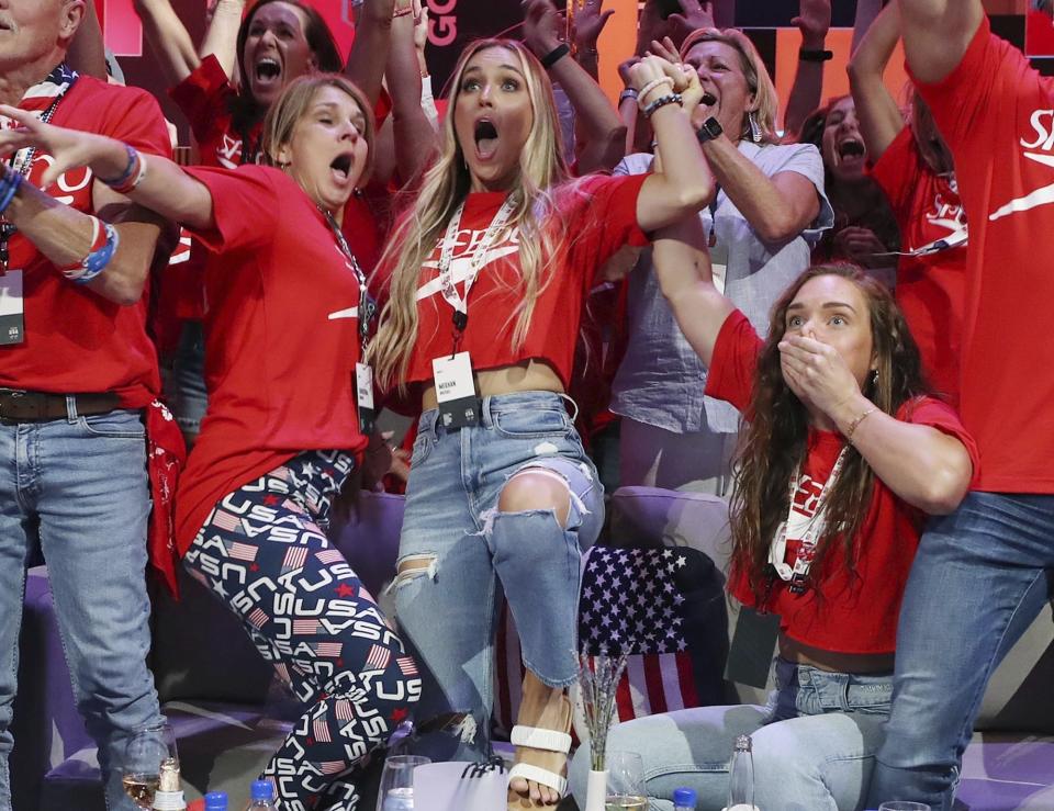 Christina Dressel, left, mother of Caeleb Dressel, and Meghan Dressel, his wife, both fall down Friday, July 30, 2021, in Orlando, Fla., as they react as Dressel's win in the 100-meter butterfly in swimming at the Tokyo Olympics Dressel's family was watching the Olympics live broadcast at the Olympic Family & Friends Experience at Universal Orlando. (Stephen M. Dowell/Orlando Sentinel via AP)